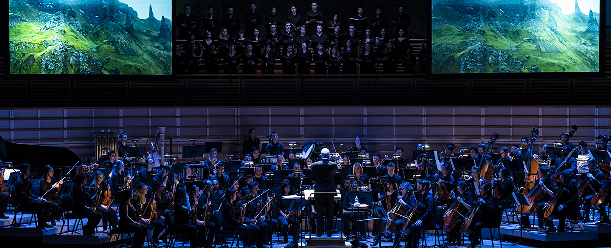 Orchestra and chorus perform live on stage